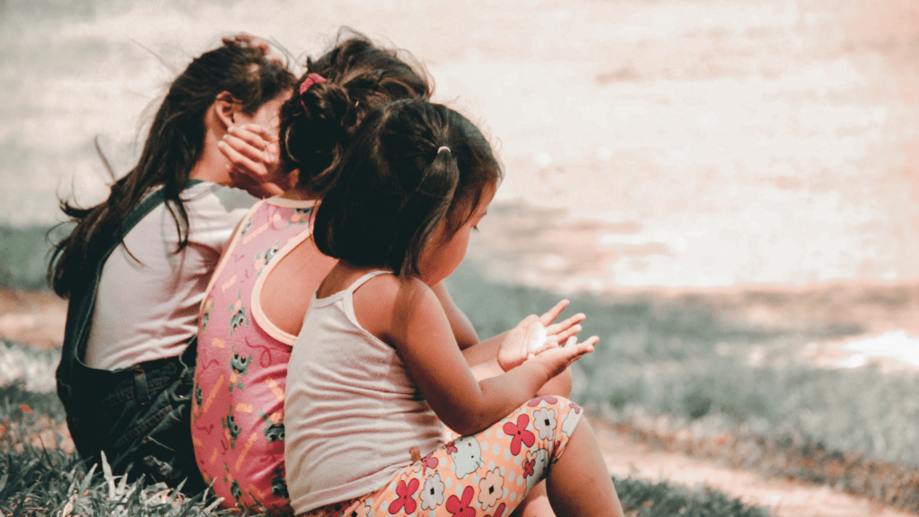 three little girls photographed sitting down from behind